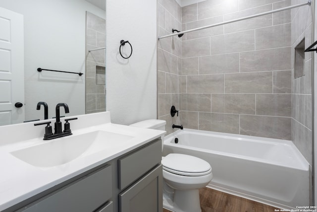 full bathroom featuring toilet, vanity, tiled shower / bath combo, and hardwood / wood-style floors