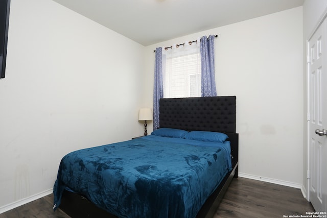 bedroom with dark hardwood / wood-style flooring