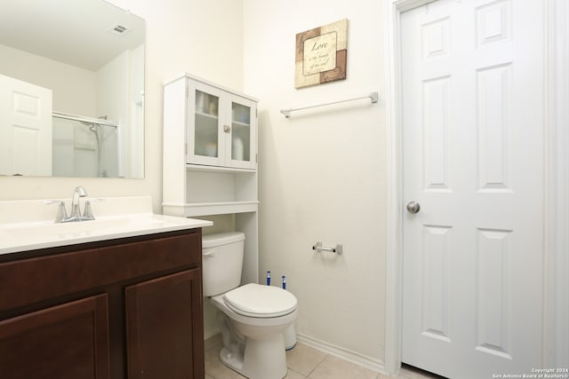 bathroom with toilet, walk in shower, vanity, and tile patterned floors