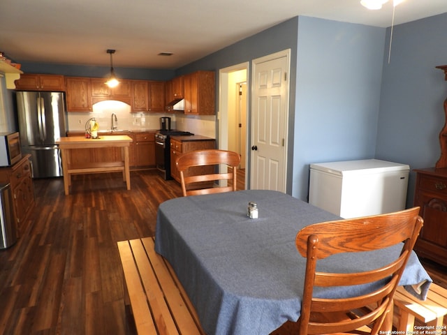 dining area featuring sink and dark hardwood / wood-style flooring