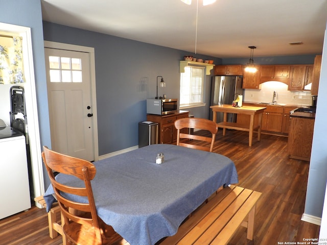 dining area featuring washer / clothes dryer, dark hardwood / wood-style floors, and sink