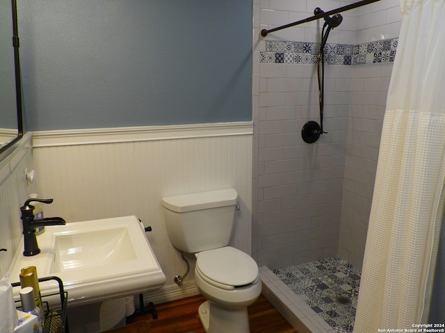 bathroom with sink, hardwood / wood-style floors, curtained shower, and toilet