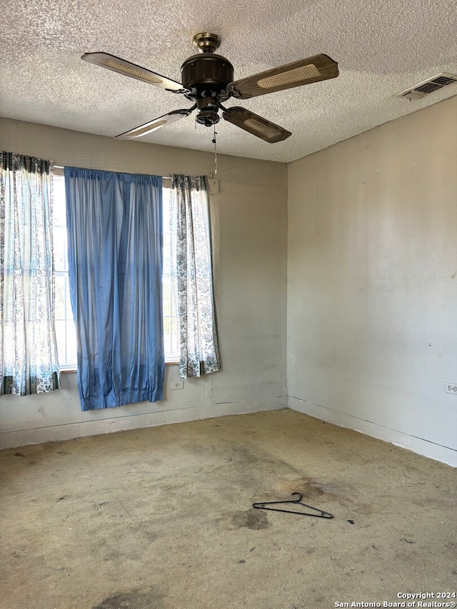 spare room featuring a textured ceiling, a healthy amount of sunlight, and ceiling fan