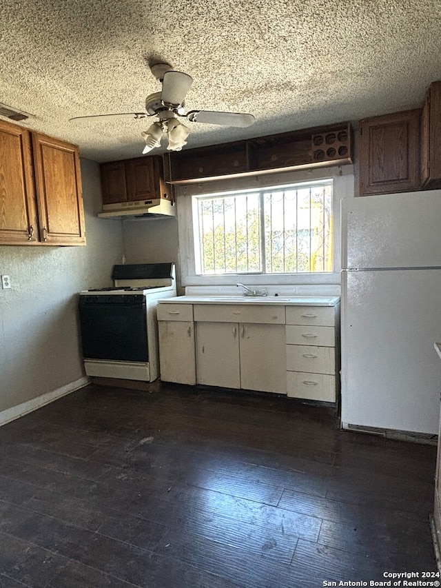 kitchen with sink, ceiling fan, a textured ceiling, white appliances, and dark hardwood / wood-style flooring