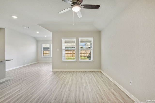 spare room with vaulted ceiling, light wood-type flooring, and ceiling fan