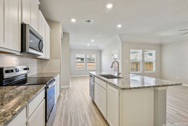 kitchen featuring appliances with stainless steel finishes, sink, a center island with sink, and white cabinets