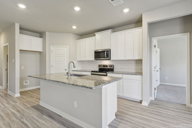 kitchen featuring white cabinetry, appliances with stainless steel finishes, sink, and a kitchen island with sink