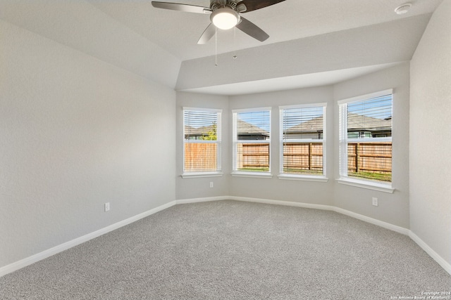 empty room featuring lofted ceiling, carpet floors, and ceiling fan