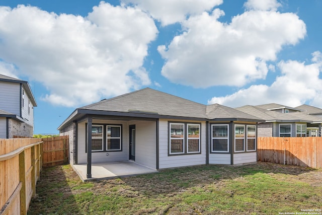 back of property with a patio and a yard