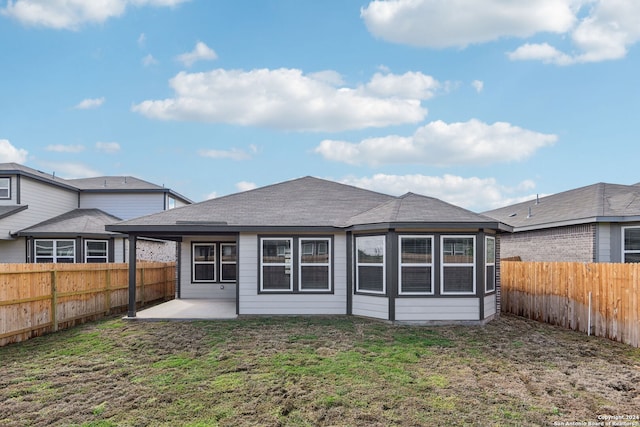 back of property with a patio area and a lawn