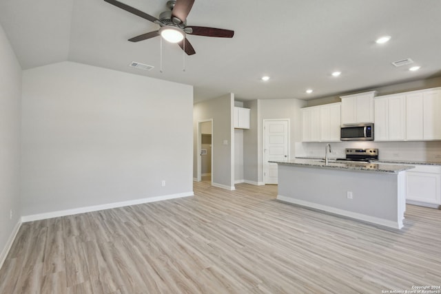 kitchen with white cabinetry, light stone counters, stainless steel appliances, and light hardwood / wood-style flooring