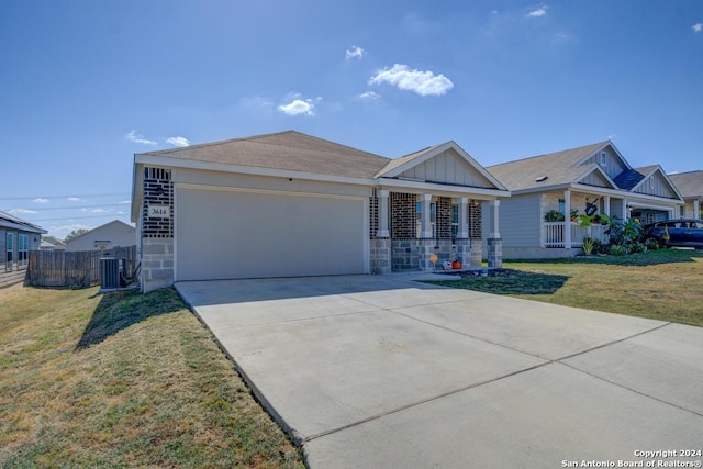 view of front of home with central air condition unit, a porch, a front lawn, and a garage