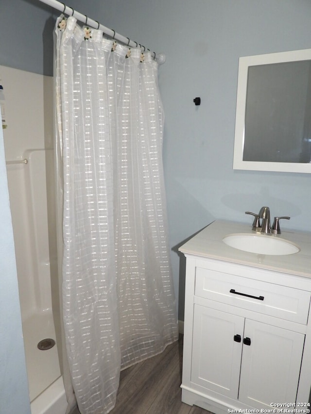 bathroom with vanity, hardwood / wood-style floors, and walk in shower