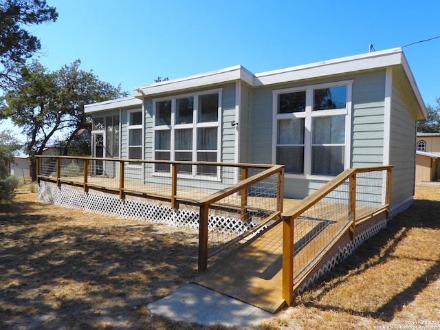 rear view of property featuring a wooden deck