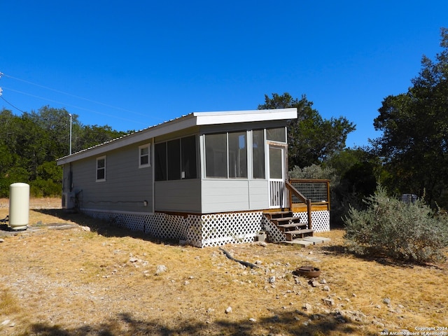 view of side of home featuring a sunroom