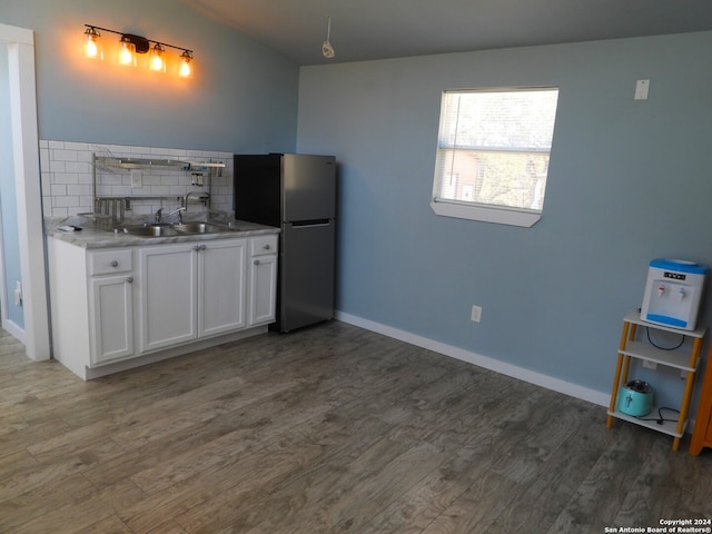 kitchen featuring white cabinets, tasteful backsplash, stainless steel refrigerator, dark hardwood / wood-style floors, and sink