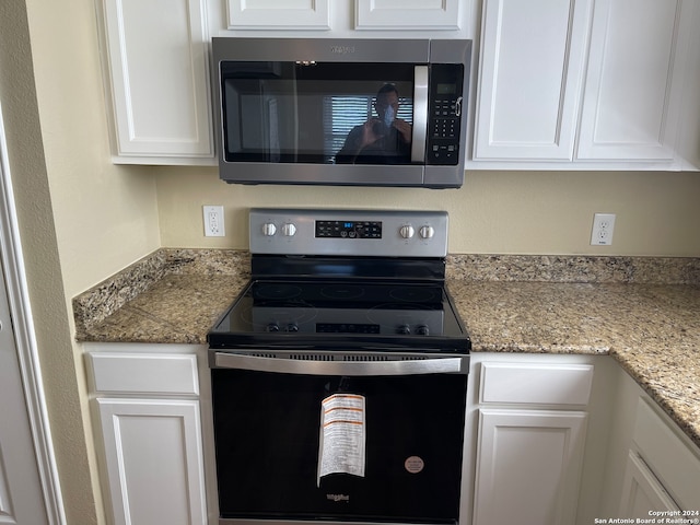 kitchen featuring light stone countertops, white cabinetry, and stainless steel appliances