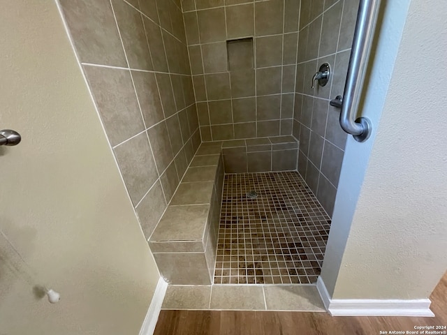 bathroom featuring a tile shower and hardwood / wood-style floors