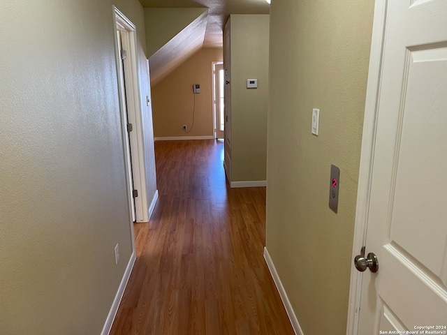 hallway featuring vaulted ceiling and light wood-type flooring