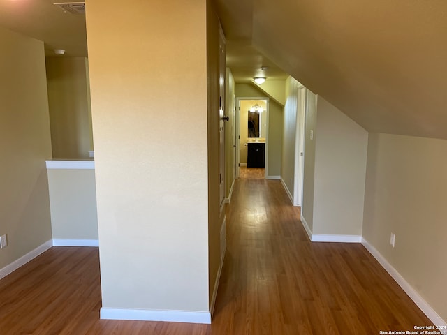 hallway featuring hardwood / wood-style flooring and lofted ceiling