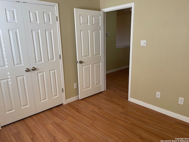 unfurnished bedroom featuring light hardwood / wood-style flooring and a closet