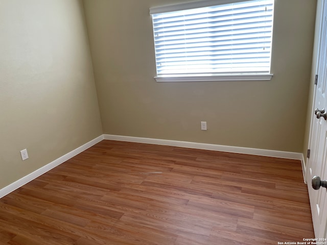 empty room with hardwood / wood-style flooring