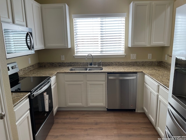 kitchen with sink, white cabinets, dark wood-type flooring, and stainless steel appliances