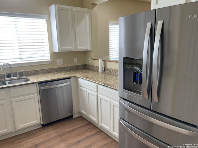 kitchen featuring light hardwood / wood-style floors, stainless steel appliances, sink, and white cabinets