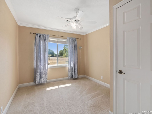 empty room with ornamental molding, light colored carpet, and ceiling fan