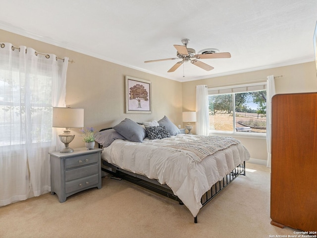 bedroom with light carpet, crown molding, and ceiling fan