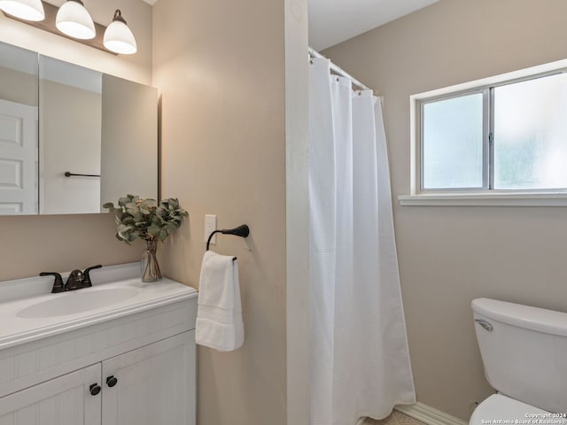 bathroom with vanity, curtained shower, and toilet