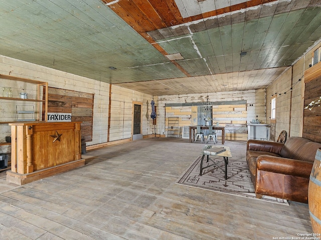 living room featuring wooden walls, wood ceiling, and wood-type flooring