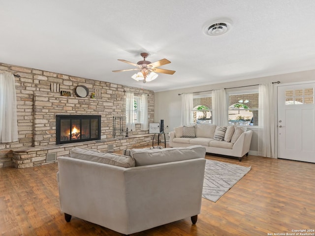 living room with ornamental molding, hardwood / wood-style floors, a fireplace, and ceiling fan