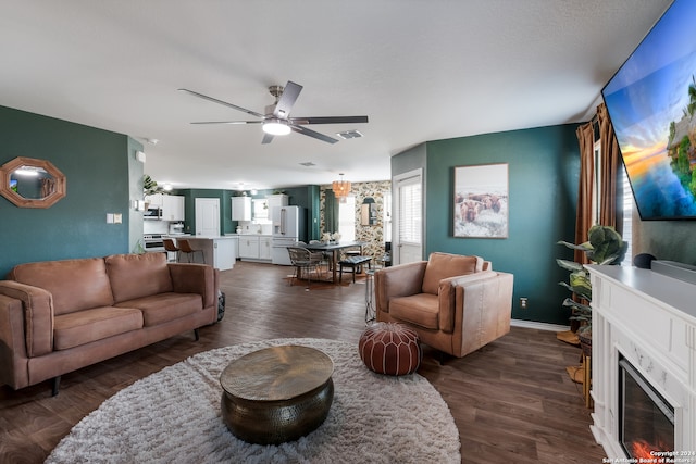 living room with ceiling fan and dark hardwood / wood-style flooring