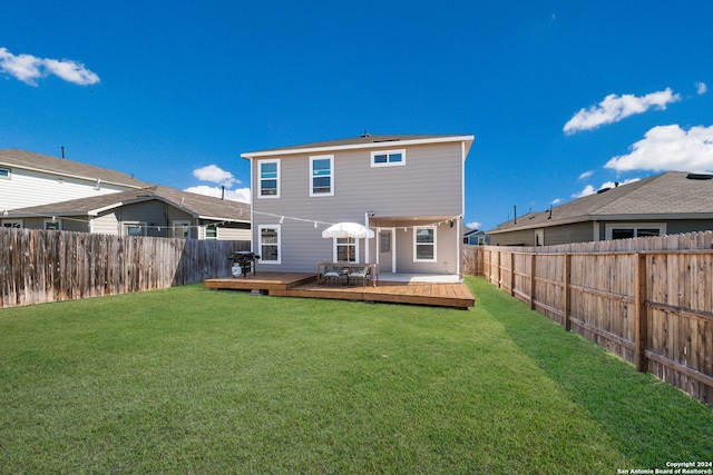 rear view of property with a wooden deck and a yard