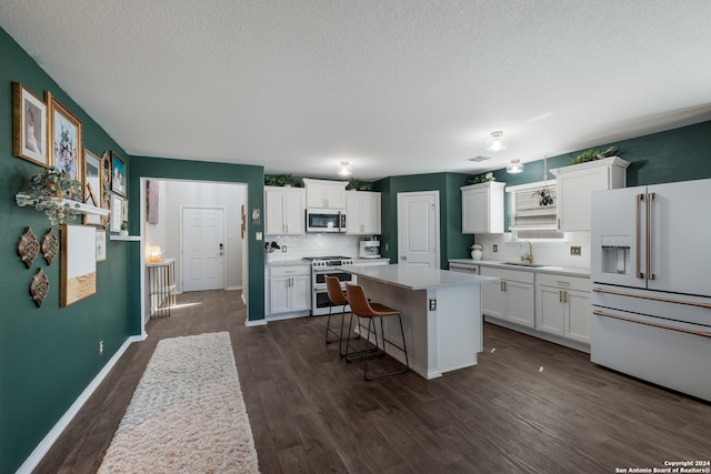 kitchen featuring a kitchen island, appliances with stainless steel finishes, white cabinets, and dark hardwood / wood-style flooring