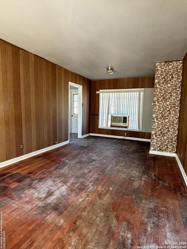 spare room with wood walls, dark wood-type flooring, and cooling unit