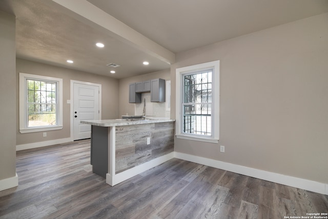 kitchen with gray cabinets, kitchen peninsula, and dark hardwood / wood-style floors