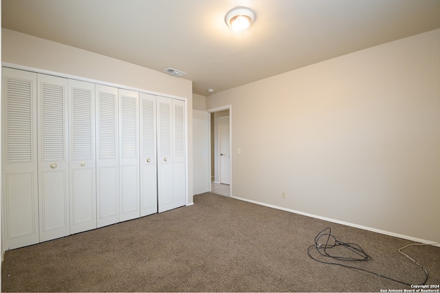 unfurnished bedroom with a closet and carpet floors