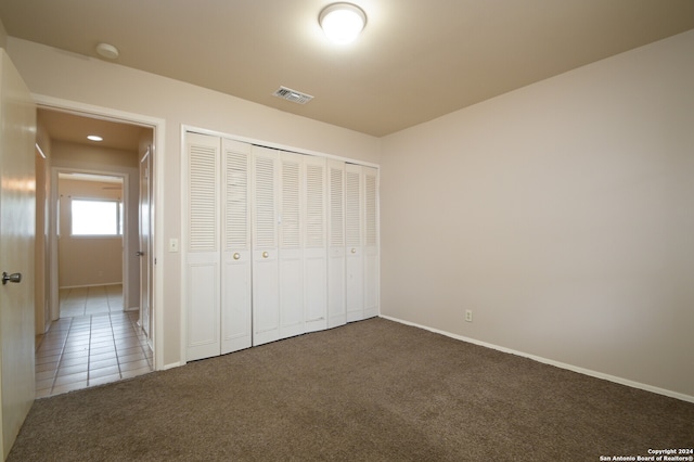 unfurnished bedroom featuring carpet floors and a closet