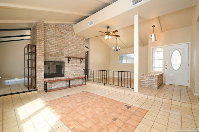 unfurnished living room with ceiling fan with notable chandelier, a brick fireplace, beamed ceiling, high vaulted ceiling, and light tile patterned floors