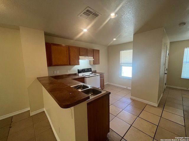 kitchen featuring kitchen peninsula, sink, light tile patterned flooring, a breakfast bar, and white electric range oven