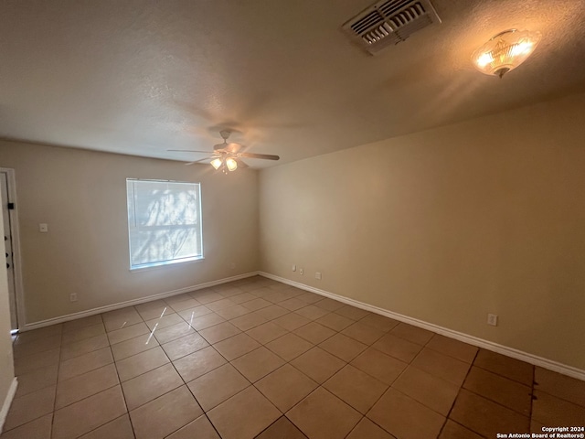 spare room featuring ceiling fan and light tile patterned floors