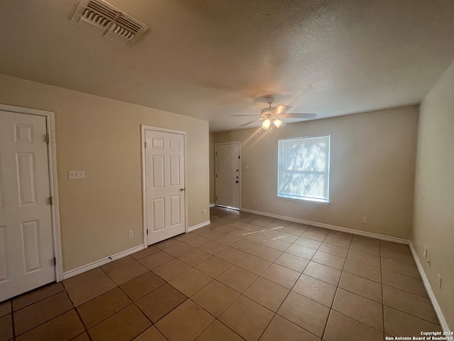 bonus room featuring light tile patterned flooring, a textured ceiling, and ceiling fan