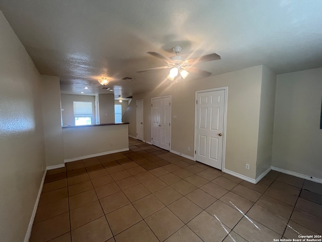 tiled spare room with ceiling fan