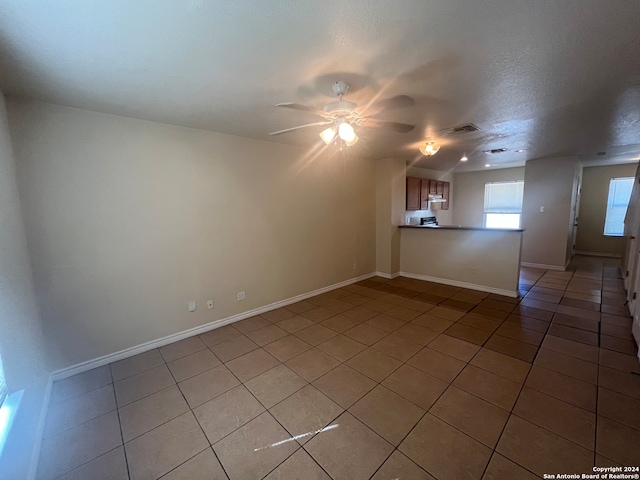 empty room featuring ceiling fan, tile patterned floors, and a textured ceiling