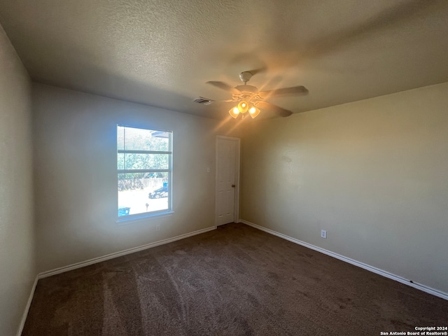 carpeted spare room featuring ceiling fan and a textured ceiling