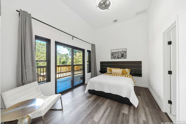 bedroom featuring access to exterior, vaulted ceiling, and dark hardwood / wood-style flooring