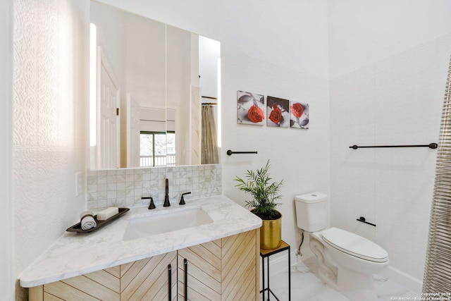 bathroom featuring vanity, toilet, and backsplash