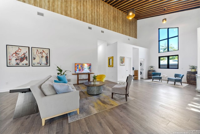 living room with hardwood / wood-style flooring and a towering ceiling